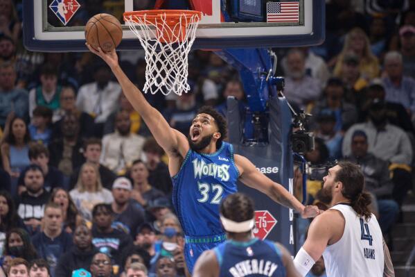 Minnesota Timberwolves center Karl-Anthony Towns (32) shoots ahead of Memphis Grizzlies center Steven Adams (4) during the first half of Game 1 of a first-round NBA basketball playoff series Saturday, April 16, 2022, in Memphis, Tenn. (AP Photo/Brandon Dill)