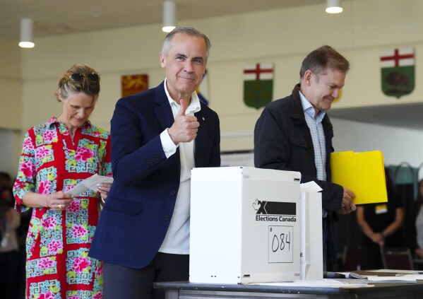Canada's new Prime Minister and Liberal Leader Mark Carney votes with his wife Diana Fox Carney in Ottawa, Ontario, Monday, April 28, 2025. (Sean Kilpatrick/The Canadian Press via AP)