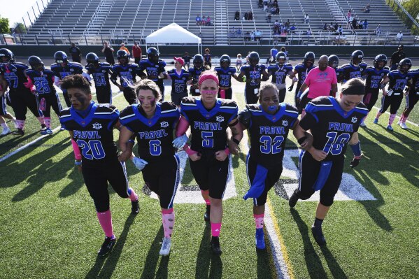 Detroit Prowl's Toya Shinaul, from left to right, Kelly Bernadyn, Sydney Hebel, Jasmine Hamilton and Allie Gorcyca walk out for the coin toss at the start of an AWFL women's football game against the Lansing Legacy, in Allen Park, Mich., Saturday, May 10, 2025. (AP Photo/Paul Sancya)