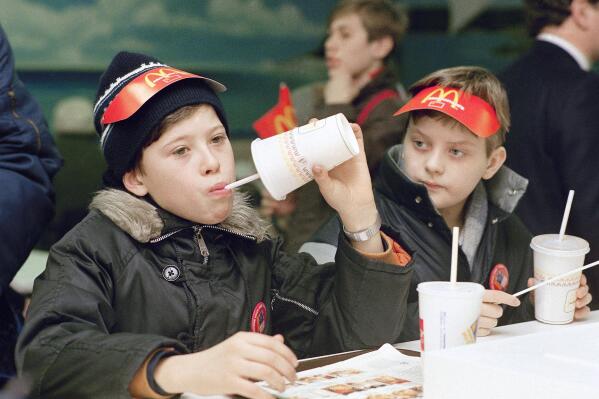 FILE - Young Muscovites checks out a new taste sensation for the Soviet Union, hamburgers and soft drinks in Moscow on Jan. 31, 1990.  McDonald’s said Thursday, May 19, 2022, it has begun the process of selling its Russian business to one of its licensees in the country. The Chicago burger giant said Alexander Govor, who operates 25 restaurants in Siberia, has agreed to buy McDonald’s 850 Russian restaurants and operate them under a new brand. McDonald’s didn’t disclose the sale price. (AP Photo/Rudi Blaha, File)