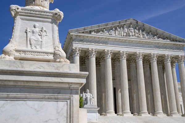 FILE - The U.S. Supreme Court is seen, with a carving of Justice in the foreground, April 19, 2023, in Washington. A Black Ohio woman who miscarried in her bathroom has been charged with abuse of a corpse and awaits grand jury action. Her case has sparked a national firestorm over the plight of pregnant women, especially women of color, following the U.S. Supreme Court’s decision to overturn Roe v. Wade. (AP Photo/Jacquelyn Martin, File)