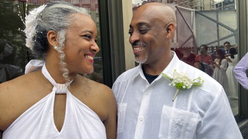 Hazel Seivwright-Carney and her husband, Rohan Carney, smile at one another, at New York's Lincoln Center, Saturday, July 8, 2023. The couple came to renew their vows at a mass wedding Saturday, after eloping 28 years earlier. (AP Photo/Bobby Caina Calvan)