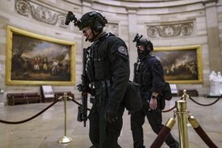 FILE - Members of the U.S. Secret Service Counter Assault Team walk through the Rotunda as they and other federal police forces responded as violent protesters loyal to President Donald Trump stormed the U.S. Capitol in Washington, Jan. 6, 2021. Top congressional Democrats are demanding that the Department of Homeland Security’s inspector general hand over information on deleted Secret Service text messages related to the Jan. 6, 2012 attack on the Capitol, accusing him of using delay tactics to stonewall their investigation.  (AP Photo/J. Scott Applewhite, File)