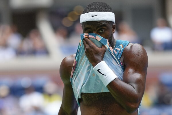 Frances Tiafoe, of the United States, wipes sweat from his face during a match against Learner Tien, of the United States, in the first round of the U.S. Open tennis championships, Aug. 28, 2023, in New York. (AP Photo/Manu Fernandez)
