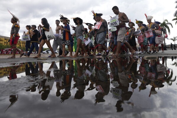 Indigenous people from across the country march in favor of the demarcation of Indigenous lands, and against a law before the Supreme Court that includes a time frame, in Brasilia, Brazil, Wednesday, Aug. 30, 2023. The time frame refers to the stipulation that Indigenous people must have been physically occupying their ancestral lands before Oct. 1988, when Brazil's constitution was signed, in order for their territorial claims to remain valid today. (AP Photo/Eraldo Peres)