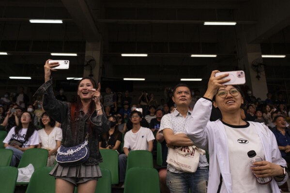 Visitors react as they watch a horse race at the Macao Jockey Club in Macao, Saturday, March 30, 2024. After more than 40 years, Macao’s horse racing track hosted its final races on Saturday, bringing an end to the sport in the city famous for its massive casinos. (AP Photo/Louise Delmotte)