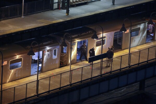 New York Police walk through the Mount Eden subway station while investigating a shooting on the platform, Monday, Feb. 12, 2024, in the Bronx borough of New York. (AP Photo/Cedar Attanasio)