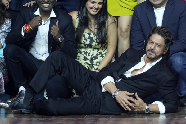 FILE - Bollywood superstar Shah Rukh Khan lies on the floor with others during a press conference after the success of his film 'Jawaan' in Mumbai, India on September 15, 2023.  India's Hindi-language film industry, Bollywood, posted an impressive financial recovery in 2023 after a pandemic-induced recession, audience fatigue with big studio productions and Bollywood megastars, and streaming platforms snatching up a large share of viewership.  (AP Photo/Rajneesh Kakade, File)