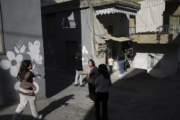 Residents walk through the streets after attending early Mass at the Maronite Church of St. George in Quraye, near the southern port city of Sidon, Lebanon, Friday, April 18, 2025. (AP Photo/Hassan Ammar)