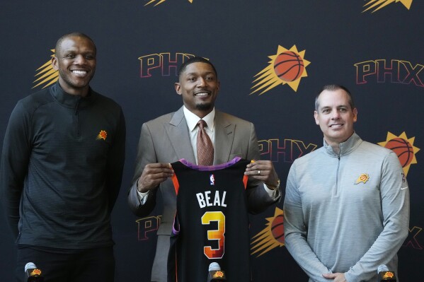 New Phoenix Suns guard Bradley Beal, middle, is flanked by Suns president of basketball operations and general manager James Jones and had coach Frank Vogel, right, as Beal holds up a new Suns jersey during an NBA basketball news conference Thursday, June 29, 2023, in Phoenix. (AP Photo/Ross D. Franklin)
