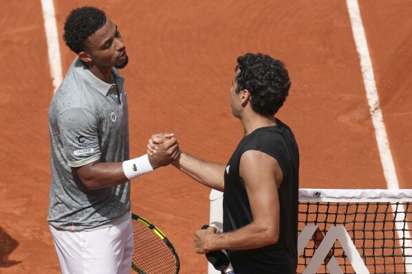 France's Arthur Fils, left, greets Spain's Jaume Munar after winning their second round match of the French Tennis Open, at the Roland-Garros stadium, in Paris, Thursday, May 29, 2025. (AP Photo/Christophe Ena)