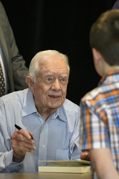 
              Former President Jimmy Carter signs copies of his new book "Faith: A Journey For All" Wednesday, April 11, 2018, in Atlanta. (AP Photo/John Amis)
            