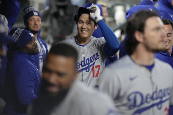 Los Angeles Dodgers designated hitter Shohei Ohtani (17) celebrates in the dugout after hitting a solo home run during the seventh inning of a baseball game against the Minnesota Twins, Monday, April 8, 2024, in Minneapolis. (AP Photo/Abbie Parr)