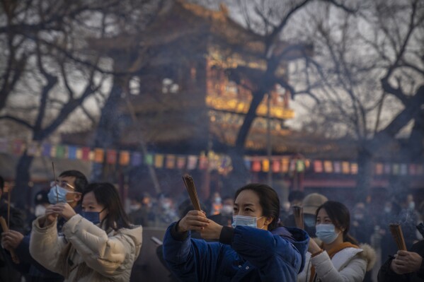 FILE - Visitors burn incense as they pray on the first day of the Lunar New Year holiday at the Lama Temple in Beijing on Jan. 22, 2023. (APPhoto/Mark Schiefelbein, File)