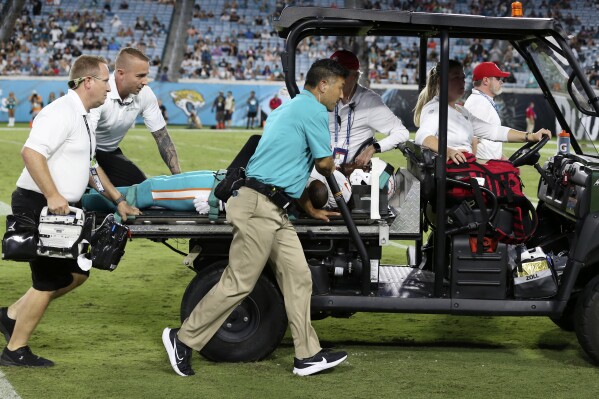 Miami Dolphins wide receiver Daewood Davis is carted off the field during the second half of an NFL preseason football game against the Jacksonville Jaguars, Saturday, Aug. 26, 2023, in Jacksonville, Fla. (AP Photo/Gary McCullough)
