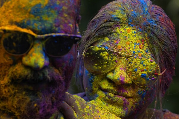 Faces of a couple are smeared with colored powder as they celebrate Holi, the Hindu festival of colors, in Mumbai, India, Monday, March 25, 2024. (AP Photo/Rafiq Maqbool)
