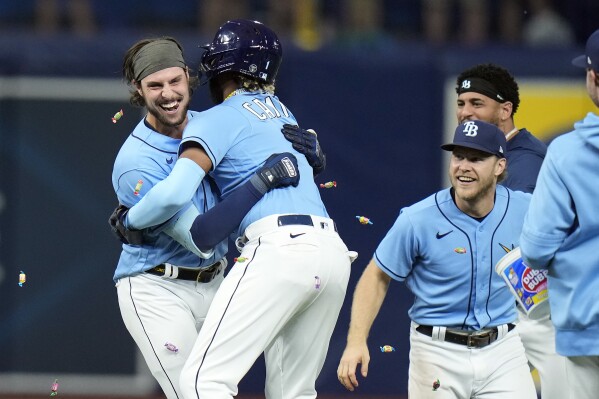 Tampa Bay Rays' Josh Lowe, left, hugs Junior Caminero as Lowe celebrates his walk-off single off Toronto Blue Jays relief pitcher Jordan Romano during the ninth inning of a baseball game Saturday, Sept. 23, 2023, in St. Petersburg, Fla. (AP Photo/Chris O'Meara)