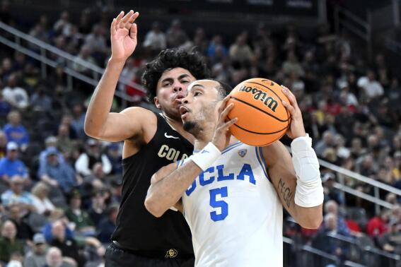 UCLA guard Amari Bailey (5) drives to the basket against Colorado guard Julian Hammond III during the second half of an NCAA college basketball game in the quarterfinals of the Pac-12 Tournament, Thursday, March 9, 2023, in Las Vegas. (AP Photo/David Becker)