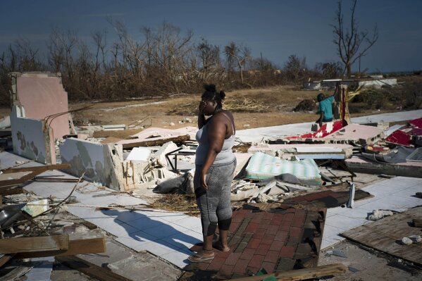 A woman is overcome as she looks at her house destroyed by Hurricane Dorian, in High Rock, Grand Bahama, Bahamas, Friday Sept. 6, 2019. The Bahamian health ministry said helicopters and boats are on the way to help people in affected areas, though officials warned of delays because of severe flooding and limited access.  (AP Photo/Ramon Espinosa)