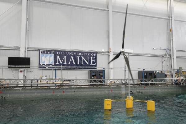 A 13-foot-tall wind turbine floats in a wave pool, Wednesday, March 27, 2024, at the University of Maine, in Orono, Maine. At UMaine more than 50 engineers comprise the largest floating offshore wind team in the U.S.(AP Photo/Robert F. Bukaty)