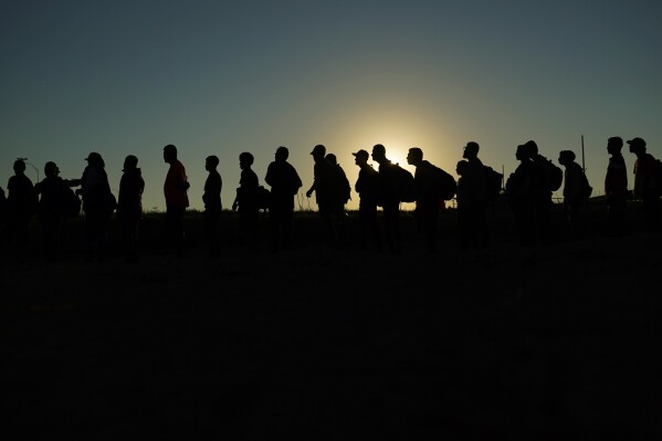 FILE - Migrants who crossed the Rio Grande and entered the U.S. from Mexico are lined up for processing by U.S. Customs and Border Protection, on Saturday, Sept. 23, 2023, in Eagle Pass, Texas. The U.S.-Mexico border and immigration are creating political and security challenges for President Joe Biden. Even some of his top allies worry about those issues' effects on his reelection chances. (AP Photo/Eric Gay, File)