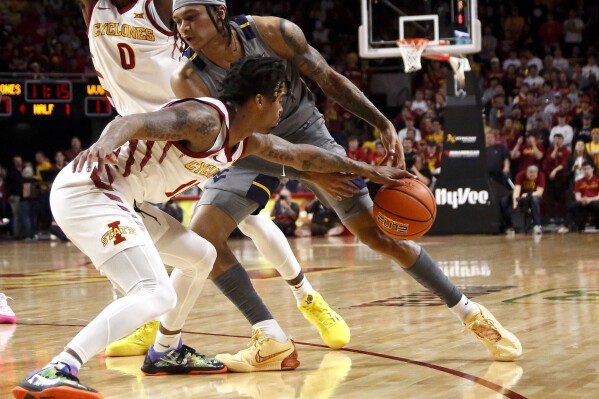 Iowa State guard Keshon Gilbert, left, steals the ball away from West Virginia guard RaeQuan Battle (21) in the first half during an NCAA college basketball game, Saturday, Feb. 24, 2024, in Ames, Iowa. (AP Photo/Bryon Houlgrave)