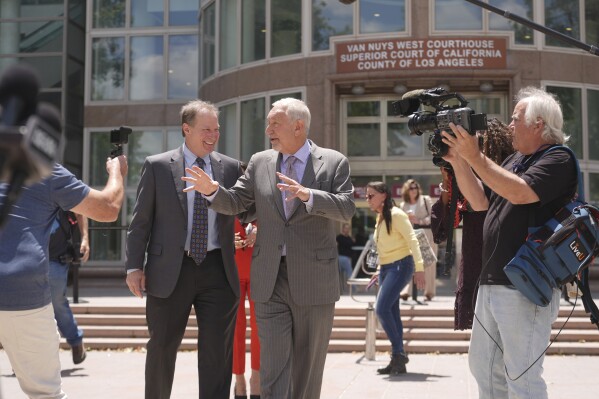 Attorney Mark Geragos, center, who represents Erik and Lyle Menendez, leaves the courthouse during break from the brothers' resentencing hearing Tuesday, May 13, 2025, in Los Angeles. (AP Photo/Damian Dovarganes)