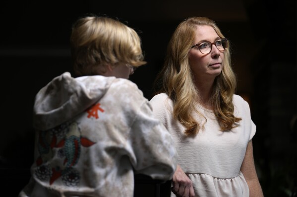 FILE - Becky Hormuth poses for a photo with her son Wednesday, Sept. 20, 2023, in Wentzville, Mo. A judge agreed Friday, Oct. 20, to step aside in a lawsuit that seeks to overturn a new Missouri law banning gender-affirming health care for minors, despite what he called “gamesmanship” from the plaintiffs' lawyers who sought a new judge. (AP Photo/Jeff Roberson, File)