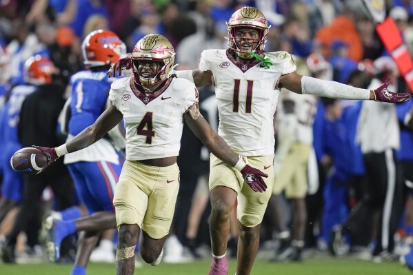 Florida State linebacker Kalen DeLoach (4) celebrates with defensive lineman Patrick Payton (11) after he intercepted a Florida pass late in the second half of an NCAA college football game Saturday, Nov. 25, 2023, in Gainesville, Fla. (AP Photo/John Raoux)