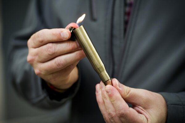 
              David Johnston, TSA's social media director, displays a lighter mounted inside of a bullet casing which was confiscated from a passenger at a Transportation Security Administration (TSA) checkpoint at Dulles International Airport in Dulles, Va., Tuesday, March 26, 2019. TSA’s social media presence has been something of a model for other federal agencies _ striking a tone is humorous, but still gives travelers informational dos and don’ts. (AP Photo/Cliff Owen)
            