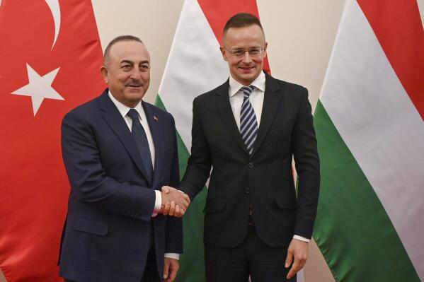 Hungarian Minister of Foreign Affairs and Trade Peter Szijjarto, right, receives Foreign Minister of Turkey Mevlut Cavusoglu for talks in his office in Budapest, Hungary, Tuesday, Jan. 31, 2023. (Tibor Illyes/MTI via AP)
