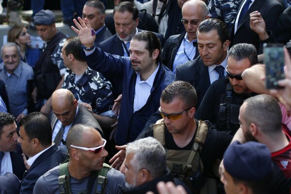 FILE - In this Sunday, May 8, 2016 file photo, Former Lebanese Prime Minister Saad Hariri, center, leader of Lebanon's parliamentary majority, waves to his supporters after he voted at a polling station during the municipal elections in Beirut, Lebanon. An explosion occurred earlier in June 2020 near the convoy of former Lebanese Prime Minister Saad Hariri when he was on a visit in a mountainous region in Lebanon's eastern Bekaa Valley, a Saudi-owned TV station reported Sunday, June 28. (AP Photo/Hassan Ammar, File)