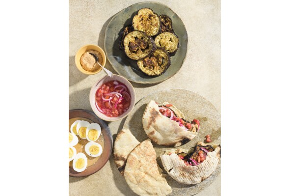 This image released by Milk Street shows a recipe for charred eggplant pita sandwiches with spicy tahini. (Milk Street via AP)