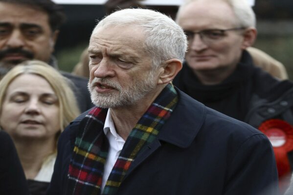 Britain's opposition Labour Party leader Jeremy Corbyn, speaks to supporters, while holding his party's manifesto, during a General Election campaign visit to Thurrock, England, Sunday Nov. 24, 2019.  Britain's Brexit is one of the main issues for political parties and for voters, as the UK goes to the polls in a General Election on Dec. 12. (Aaron Chown/PA via AP)