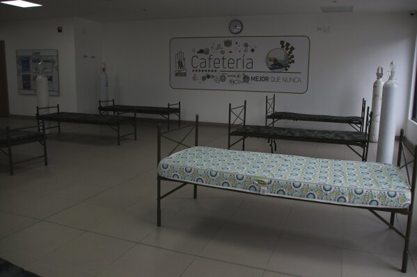 Bed frames and oxygen tanks have been installed in a cafeteria of the Seguro Social hospital in preparation for an anticipated overflow of patients infected with the new coronavirus, in Quito, Ecuador, Wednesday, July 29, 2020. The Ecuadorian capital has experienced a surge in COVID-19 cases since the government started to reopen the economy last month. (AP Photo/Dolores Ochoa)