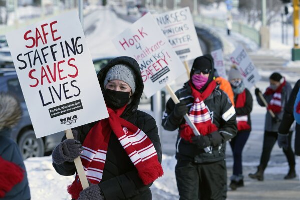 Nurses picket Friday, Feb. 12, 2021 in Faribault, Minn., during a healthcare worker protest of a shortage on protective masks. One year into the COVID-19 pandemic, the U.S.  finds itself with many millions of N95 masks pouring out of American factories and heading into storage. Yet there still aren’t nearly enough in ICU rooms and hospitals. (AP Photo/Jim Mone)