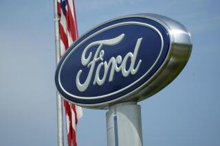 A Ford logo is seen on signage at Country Ford in Graham, N.C., Tuesday, July 27, 2021. Ford is recalling more than 330,000 Mustangs in the U.S., Wednesday, Feb. 23, 2022, to fix backup camera displays that go blank or become distorted. The recall covers cars from the 2015 to 2017 model years. (AP Photo/Gerry Broome)