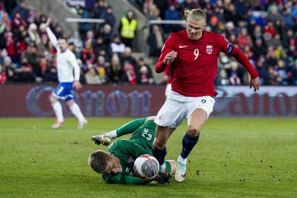 Norway's Erling Haaland, right, and Faroe Islands' goalkeeper Bardur a Reynatrod, left, challenge for the ball the international friendly soccer match between Norway and the Faroe Islands at the Ullevaal stadium in Oslo, Norway, Thursday, Nov. 16, 2023. (Cornelius Poppe /NTB Scanpix via AP)