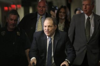 FILE - In this Monday, Feb. 24, 2020 file photo, Harvey Weinstein arrives at a Manhattan courthouse for jury deliberations in his rape trial, in New York. Britain has stripped disgraced movie mogul Harvey Weinstein of an honor recognizing his contribution to the UK film industry. The 68-year-old Weinstein was given the honor in 2004 and the decision to take it away was announced Friday Sept. 18, 2020. (AP Photo/Seth Wenig, File)