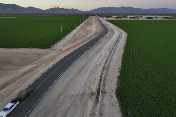 A truck hauling hay drives near Al Dahra Farms, Tuesday, Oct. 17, 2023, in the McMullen Valley in Wenden, Ariz. Worries about future water supplies from ancient aquifers are bubbling up in western rural Arizona. Some neighbors complain that their backyard wells have dried up since the Emirati agribusiness began farming alfalfa nearby. (AP Photo/John Locher)