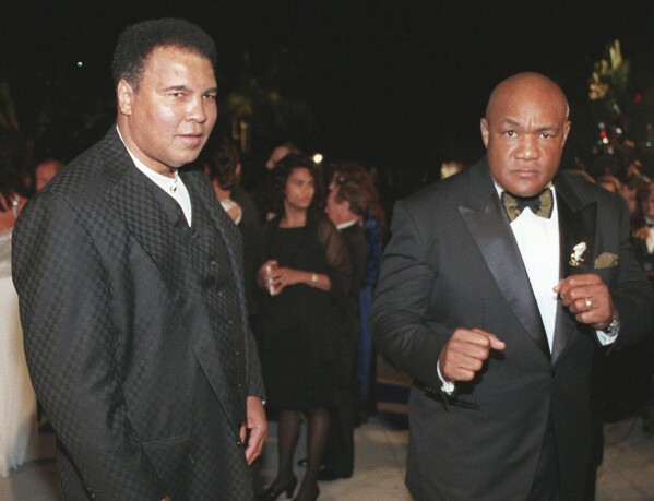 Boxing greats Muhammad Ali, left, and George Foreman arrive at a Vanity Fair Oscar party in West Hollywood, Calif., on March 24, 1997. (AP Photo/E.J. Flynn, File)