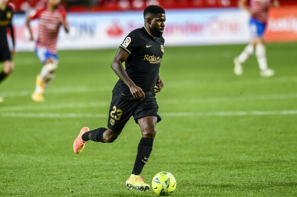 FILE - Barcelona's Samuel Umtiti runs with the ball during the Spanish La Liga soccer match between Granada and FC Barcelona at the Los Carmenes stadium in Granada, Spain, Jan. 9, 2021. Barcelona reached a deal with defender Samuel Umtiti to end his contract two years in advance. The French defender was tied with Barcelona through the end of the 2025-26 season. He played on a loan with Italian club Lecce this past campaign. (AP Photo/Jose Breton, File)