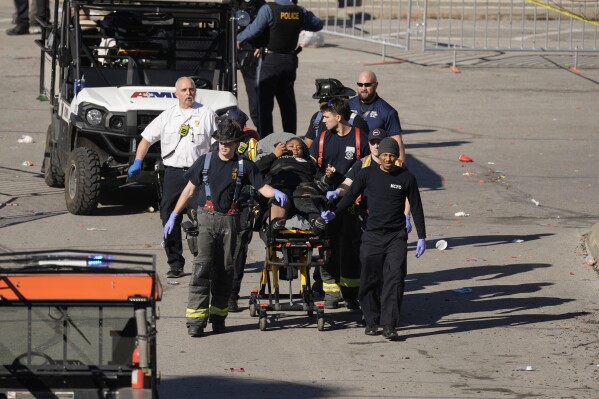 A person is taken to an ambulance after an incident following the Kansas City Chiefs victory parade in Kansas City, Mo., Wednesday, Feb. 14, 2024. The Chiefs defeated the San Francisco 49ers Sunday in the NFL Super Bowl 58 football game. (AP Photo/Charlie Riedel)