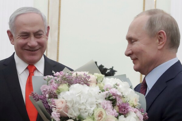 FILE - Russian President Vladimir Putin, right, prepares to greet Israeli Prime Minister Benjamin Netanyahu's wife Sara, unseen, prior to talks with Israeli Prime Minister Benjamin Netanyahu in the Kremlin in Moscow, Russia, on Jan. 30, 2020. Russia and Israel have steadily expanded trade and other contacts and strengthened security ties. (Maxim Shemetov/Pool Photo via AP, File)