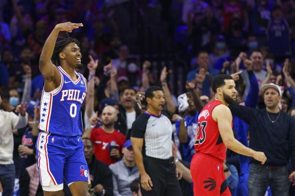 Philadelphia 76ers' Tyrese Maxey, left, reacts to his three-pointer as Toronto Raptors' Fred VanVleet, right, looks on during the first half of Game 1 of an NBA basketball first-round playoff series, Saturday, April 16, 2022, in Philadelphia. (AP Photo/Chris Szagola)