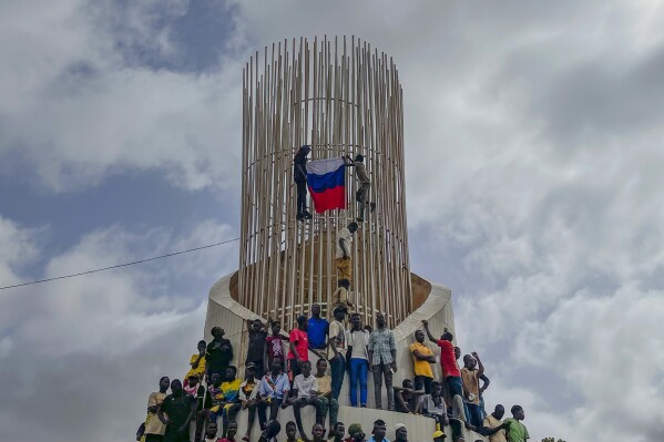 Supporters of Niger's ruling junta hold a Russian flag at the start of a protest called to fight for the country's freedom and push back against foreign interference in Niamey, Niger, Thursday, Aug. 3, 2023. The march falls on the West African nation's independence day from its former colonial ruler, France, and as anti-French sentiment spikes, more than one week after mutinous soldiers ousted the country's democratically elected president. (AP Photo/Sam Mednick)