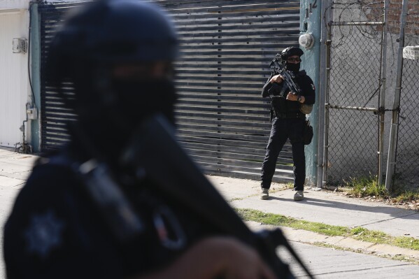 FILE - Municipal police officers patrol a neighborhood in Celaya, Guanajuato state, Mexico, Feb. 28, 2024. (AP Photo/Fernando Llano, File)