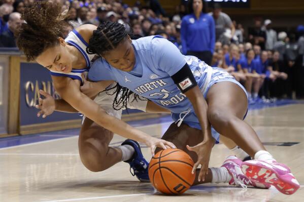 Duke's Celeste Taylor, left, and North Carolina's Anya Poole dive for the ball during the first half of an NCAA college basketball game Sunday, Feb. 26, 2023, in Durham, N.C. (Kaitlin McKeown/The News & Observer via AP)