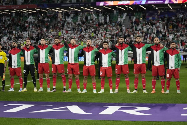 Palestinian team stand for the national anthem ahead of the Asian Cup Group C soccer match between Iran and Palestine at the Education City Stadium in Al Rayyan, Qatar, Sunday, Jan. 14, 2024. (AP Photo/Aijaz Rahi)