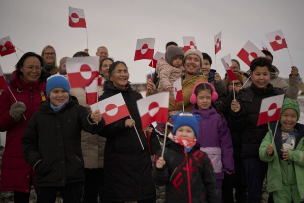 People wave Greenland flags during an event organized by Qupanuk Olsen, Greenland's most popular social media influencer and a candidate for the Naleraq party in the next March 11 election, in Nuuk, Greenland, Sunday, Feb. 16, 2025. (AP Photo/Emilio Morenatti)